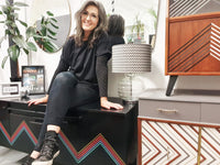 Nicky Cash designer and owner of Done up North sits on a vintage upcycled sideboard in her Studio in Leeds